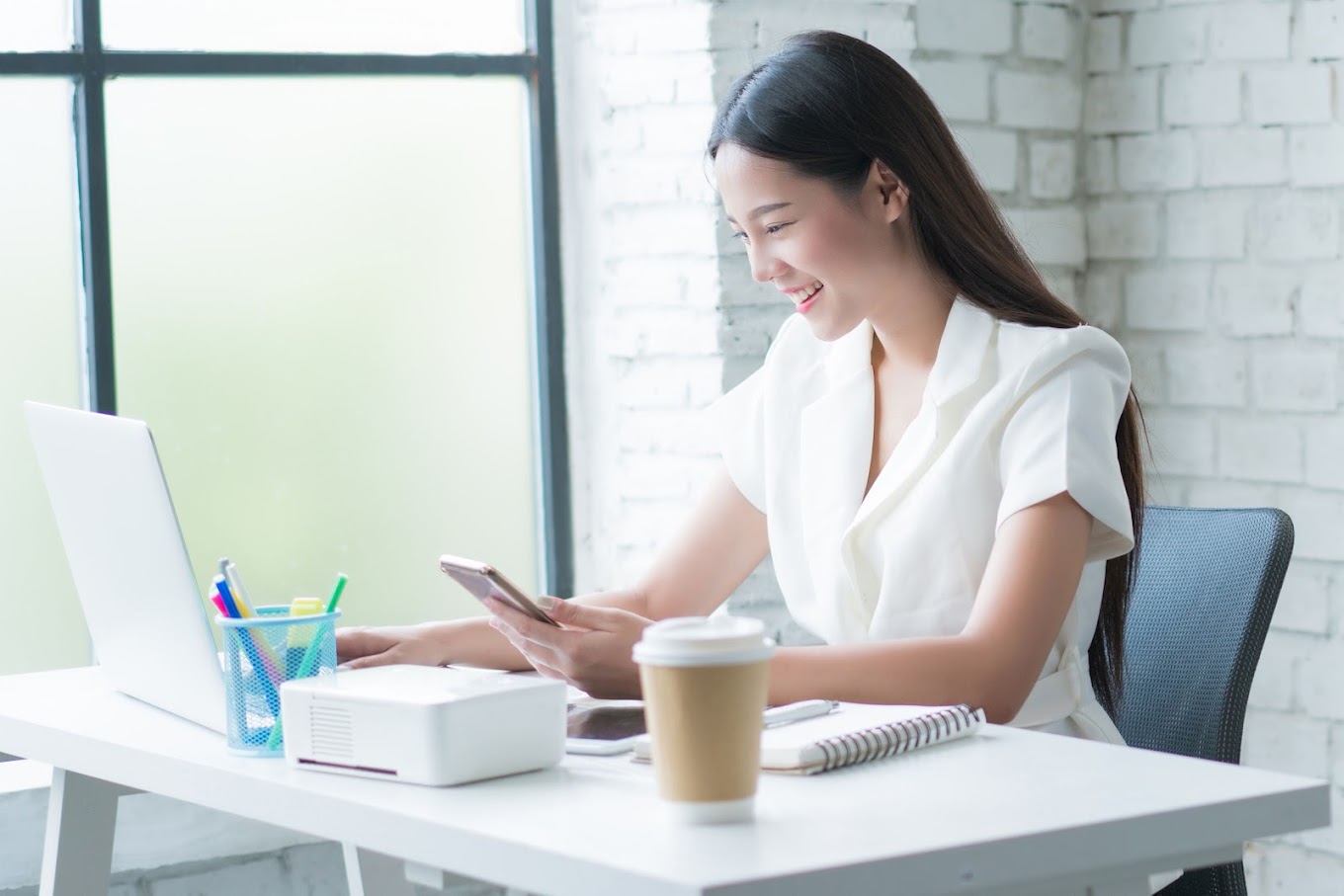 Happy small business owner at her desk after her Google Business Profile was optimized by HoopJumper resulting in more local search visibility and customer calls